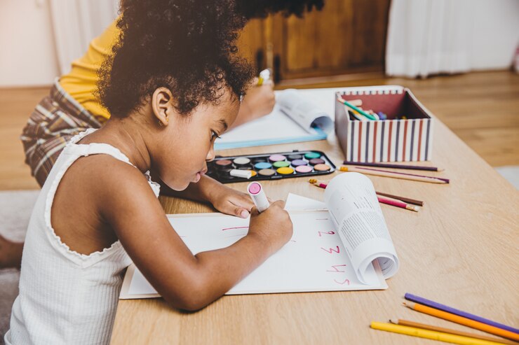 Filles préscolaires noires américaines faisant leurs devoirs apprenant l'éducation avec sa sœur vivant ensemble à la maison.