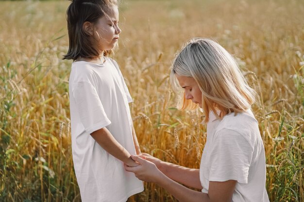 Filles priant et se tenant la main dans un champ de blé. Priez pour que Dieu se soutienne mutuellement.