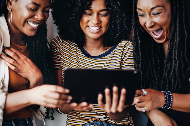 Photo filles regardant un clip vidéo en ligne sur une tablette numérique