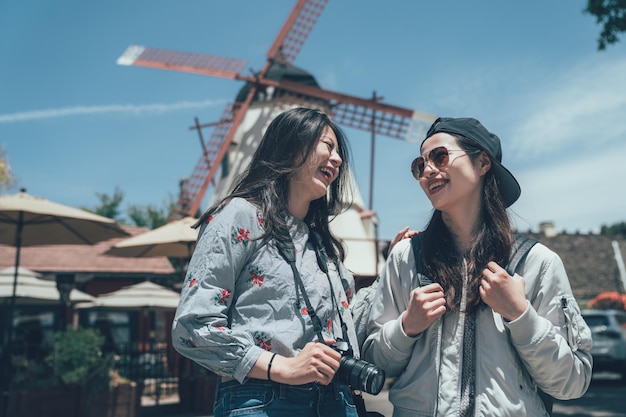 Filles regardant rire moulin à vent debout à l'arrière