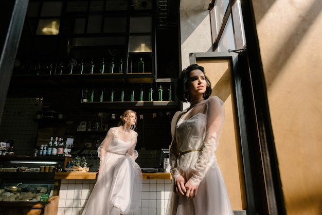 Les filles en robes de mariée blanches posent