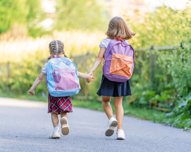 Les filles avec sac à dos vont à l'école