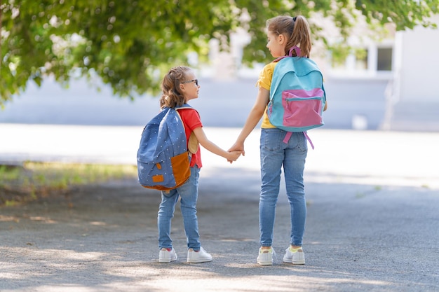 Les filles avec sac à dos vont à l'école