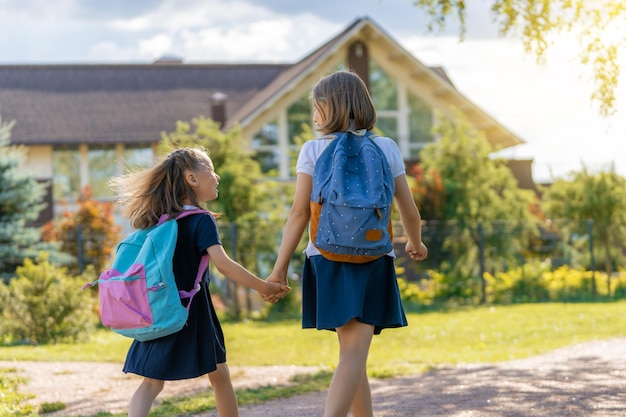 Les filles avec sac à dos vont à l'école