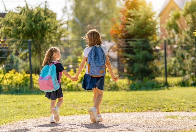 Les filles avec sac à dos vont à l'école