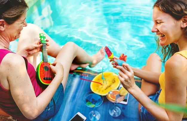 Filles se détendre au bord de la piscine