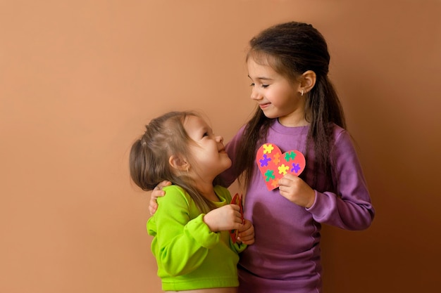 Les filles se regardent en tenant des cartes faites à la main avec des puzzles à la main