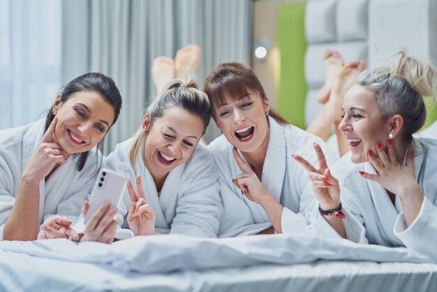 Filles à la soirée spa à l'hôtel avec téléphone