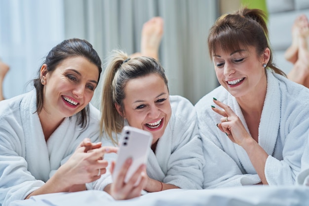 Filles à la soirée spa à l'hôtel avec téléphone