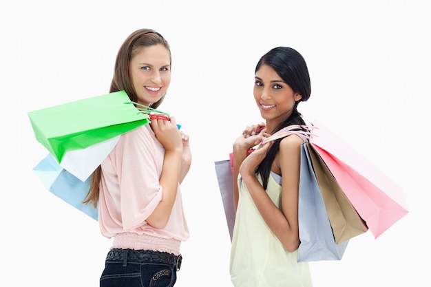 Filles souriantes avec beaucoup de sacs à provisions