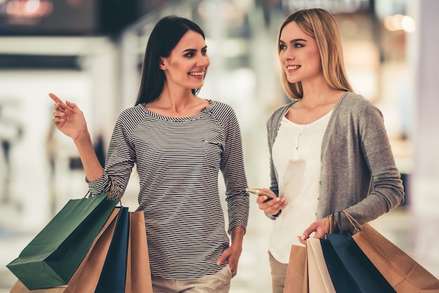 Les filles sourient en faisant des courses dans le centre commercial