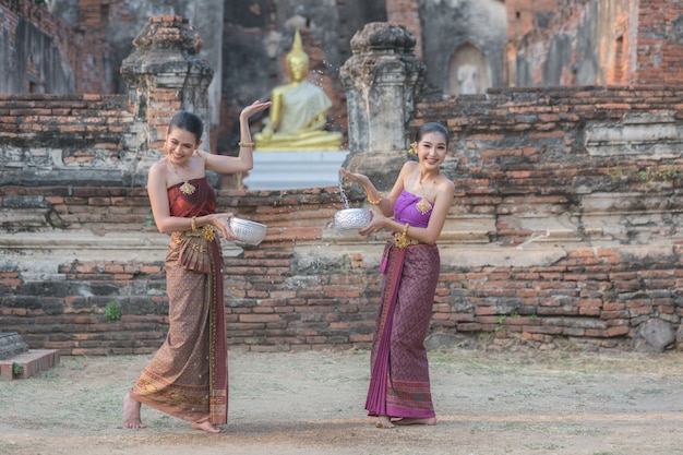 Filles thaïlandaises en costume traditionnel thaïlandais éclaboussures d&#39;eau pendant le festival Songkran, Ayutthaya, Thaïlande.