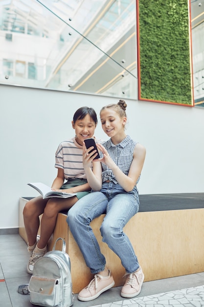 Filles utilisant un smartphone à l'école