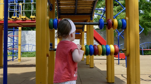 Une fillette d'un an devant le complexe de jeu à l'aire de jeux