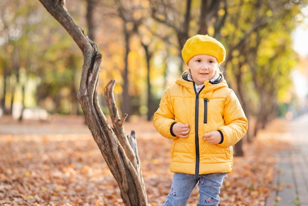 Une fillette marche dans le parc en automne