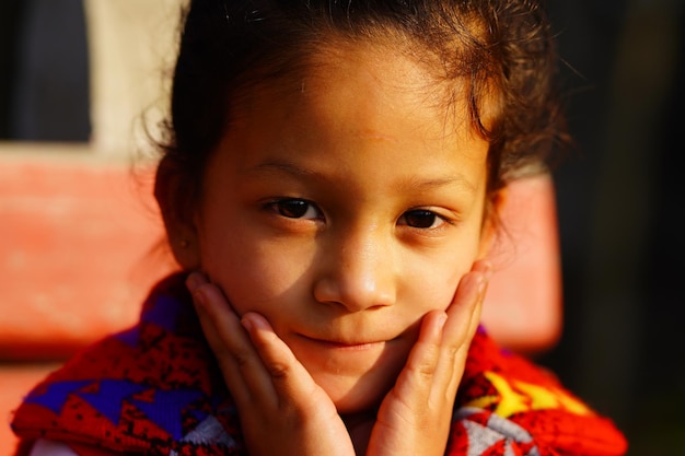 fillette sourire avec de petites mains touchantes sur son visage