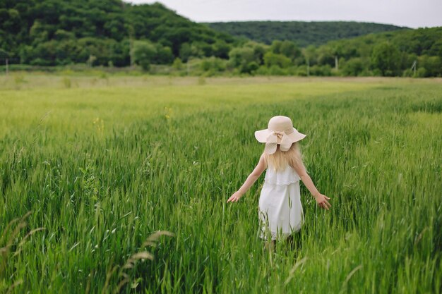 Une fillette ukrainienne libre et indépendante de 7 ans aux cheveux blancs traverse un champ de blé