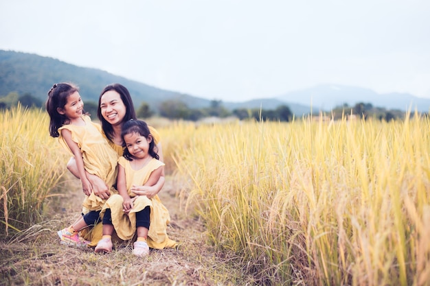 Fillettes asiatiques heureux s&#39;amuser à jouer avec la mère dans la rizière dans le ton de couleur vintage