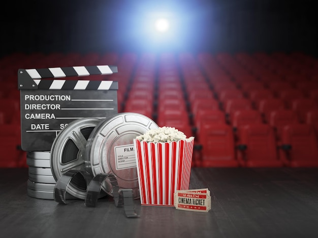 Film de cinéma ou concept de vidéo à domicile arrière-plan Bobines de film clapper board et pop corn dans l'écran de cinéma de cinéma avec des sièges vides