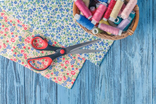 Fils à coudre multicolores sur fond de bois