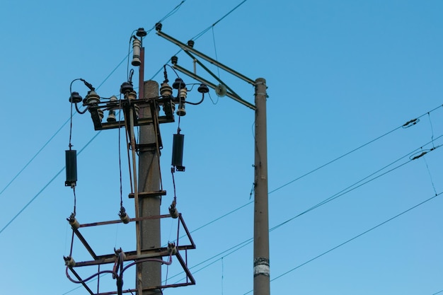 Fils électriques sur un poteau contre un ciel bleu