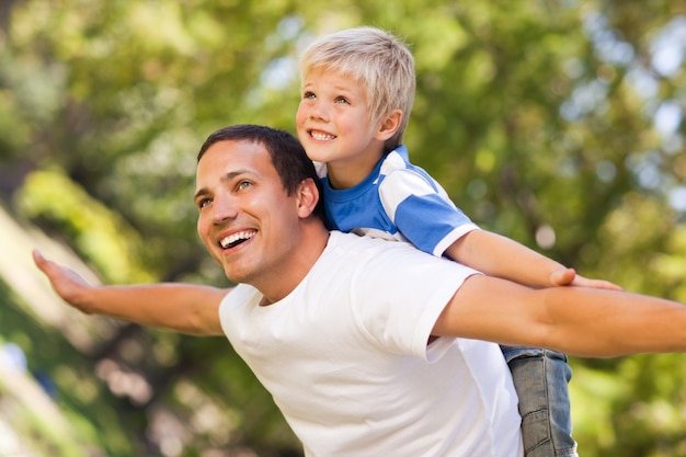 Fils jouant avec son père dans le parc