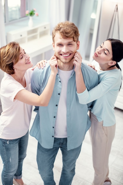 Fils et mari. Joyeux jeune homme souriant tout en appréciant d'être au centre de l'attention