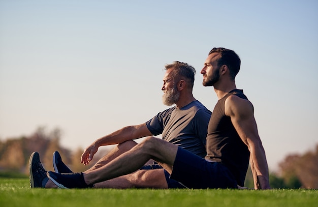 Le fils et le père assis sur l'herbe