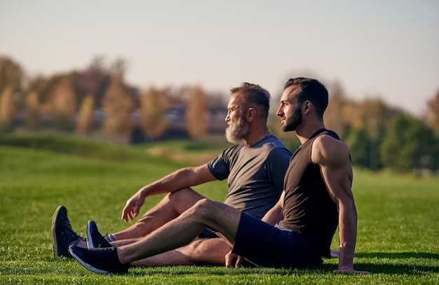 Le fils et le père assis sur l'herbe