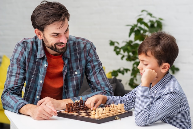 Photo fils et père jouant aux échecs