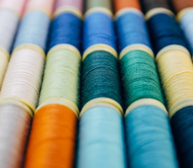 Fils en plastique colorés sur des rouleaux pour la couture