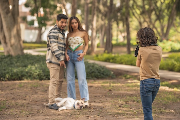 Fils prenant une photo de ses parents avec un chien à l'extérieur