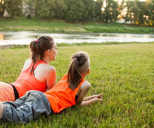 Fils et sa mère se reposant sur l'herbe après la co-formation, concept