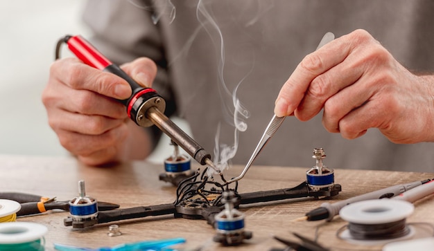 Fils à souder avec de la fumée pendant le processus de service de réparation de quadcopter