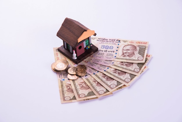 Financement et prêt ou achat de logement en Inde - Concept montrant un modèle de maison 3D, des billets de banque indiens et une calculatrice, etc.