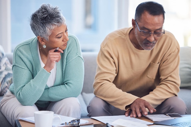 Financer l'assurance et un couple de personnes âgées avec des documents de planification fiscale et de budget domestique avec un ordinateur portable