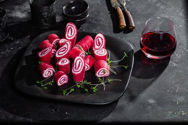 Fines crêpes rouges. Rouleaux de crêpes à la betterave avec fromage à la crème