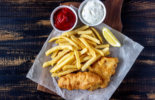 Fish and chips sur un fond en bois. Restauration rapide britannique. Recettes. Snack à la bière. Cuisine anglaise.