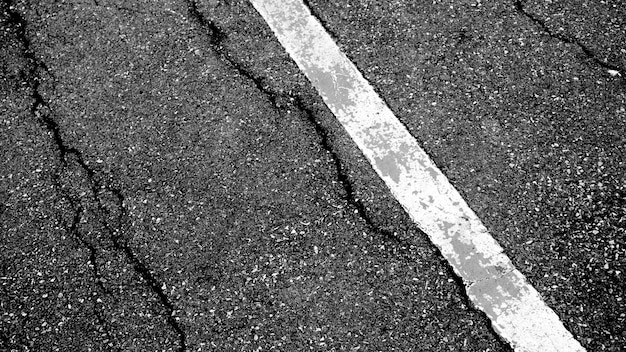 Fissure et texture de la route goudronnée avec fond vue de dessus de ligne pointillée blanche.