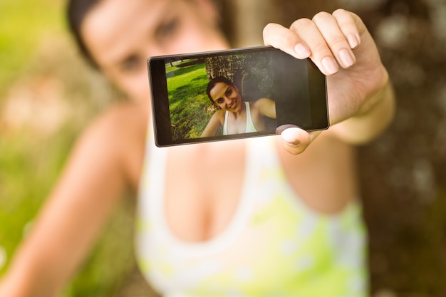 Fit brune prenant un selfie