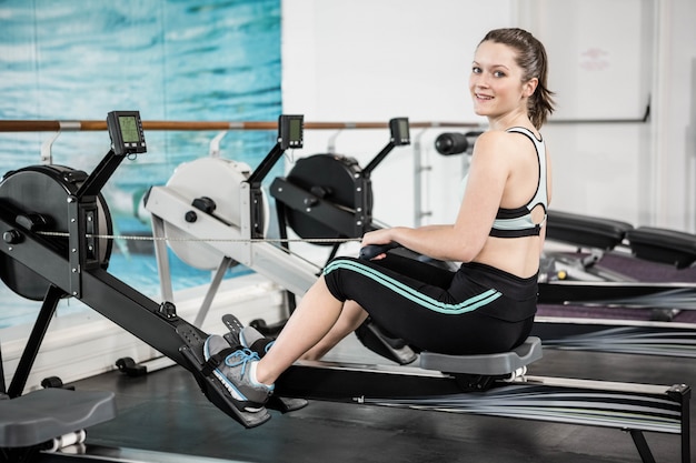 Fit brunette sur machine à dessiner à la gym