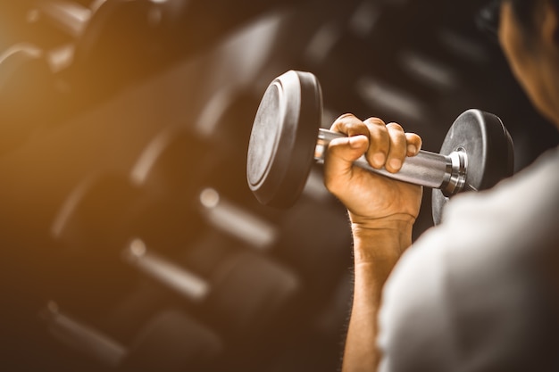 Fit caucasien jeune main dans les vêtements de sport. Jeune homme, tenue, haltère, pendant, a, exercice, clas