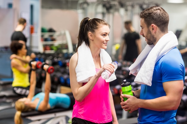 Fit couple bavardant dans la salle de musculation