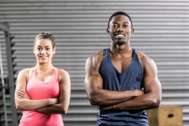 Fit couple avec bras croisés au gymnase de crossfit