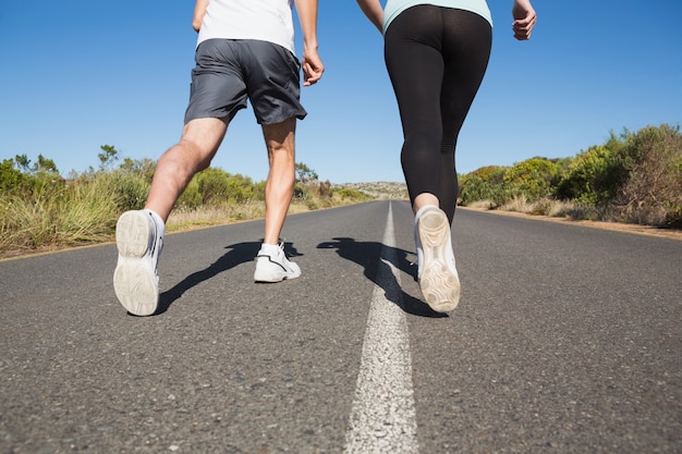 Fit couple courir sur la route ouverte ensemble