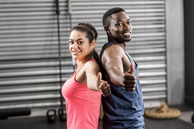 Fit couple dos à dos au gymnase