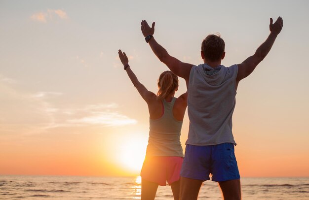 Fit couple avec leurs mains vers le haut