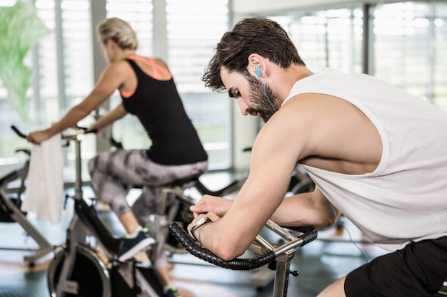 Fit couple sur des vélos d&#39;exercice à la salle de sport