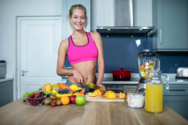 Fit femme couper des fruits dans la cuisine