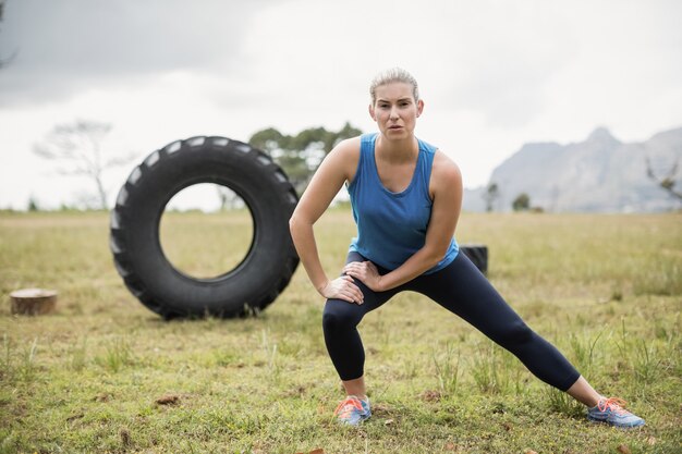 Fit femme effectuant des exercices d'étirement dans le camp d'entraînement